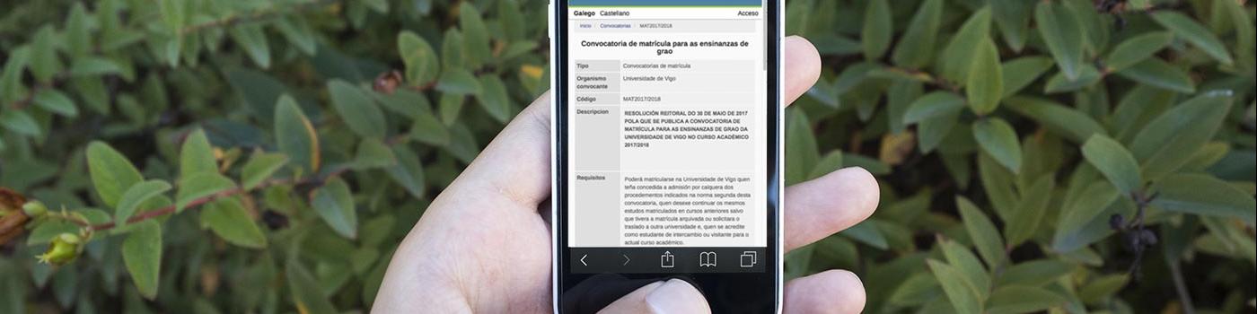 Unha persoa sostén un móbil na man. Na pantalla vemos información sobre a matrícula nos graos