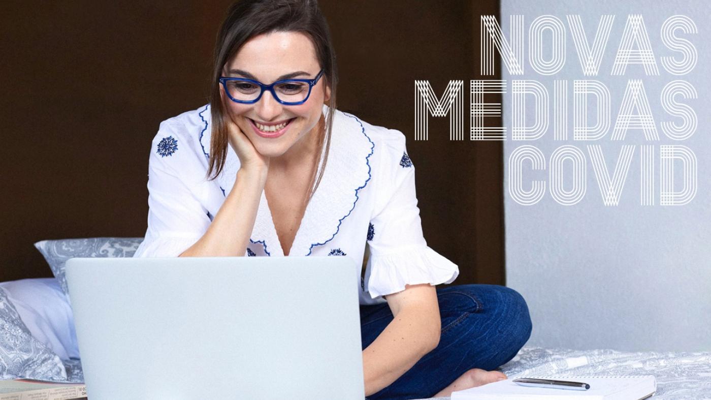 Estudante con lentes azuis estudando cun portátil