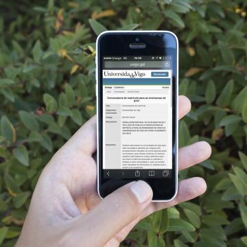 Unha persoa sostén un móbil na man. Na pantalla vemos información sobre a matrícula nos graos