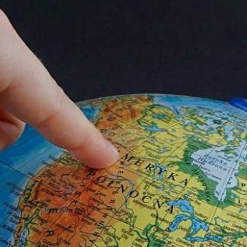 dedo sinalando un país nun globo terráqueo